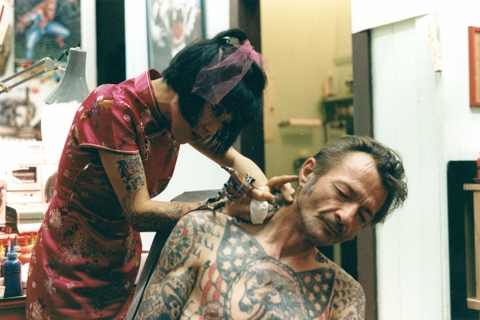Inny Lee tetováláskészítés közben a Goldfield's Tattoo stúdióban. Fotó: Tiefenbacher, Wendy, 1988 körül, San Francisco, színes pozitív, Néprajzi Múzeum; F 337662